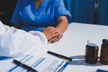 Yakın plan, doktor yaşlı bir kadınla el ele tutuşuyor ve kanser bakımı ya da destek. Sağlık hizmetleri veya güven, empati veya şefkat ve kadın bakıcı veya hemşire umut ve şefkat için yaşlı kişinin elini tutuyor.