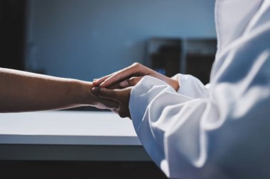 Yakın plan, doktor yaşlı bir kadınla el ele tutuşuyor ve kanser bakımı ya da destek. Sağlık hizmetleri veya güven, empati veya şefkat ve kadın bakıcı veya hemşire umut ve şefkat için yaşlı kişinin elini tutuyor.