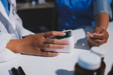 Steteskopla sfenometre kullanan bir doktor hastanede kan basıncını ölçüyor..