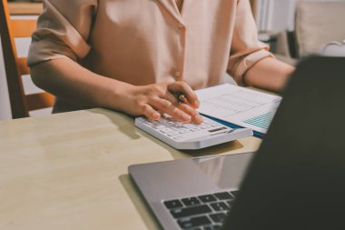 Vergi indirimi konsepti. Kadınlar kişisel gelir vergileri için vergi indirimi almak için harcamaları ve vergileri hesaplamak için bir hesap makinesi kullanıyorlar. Bireyler için vergi beyannamesi. Aylık giderler