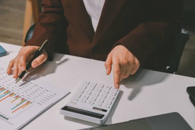 Vergi indirimi konsepti. Kadınlar kişisel gelir vergileri için vergi indirimi almak için harcamaları ve vergileri hesaplamak için bir hesap makinesi kullanıyorlar. Bireyler için vergi beyannamesi. Aylık giderler