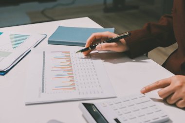 Vergi indirimi konsepti. Kadınlar kişisel gelir vergileri için vergi indirimi almak için harcamaları ve vergileri hesaplamak için bir hesap makinesi kullanıyorlar. Bireyler için vergi beyannamesi. Aylık giderler