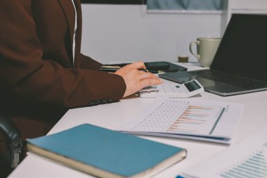 Vergi indirimi konsepti. Kadınlar kişisel gelir vergileri için vergi indirimi almak için harcamaları ve vergileri hesaplamak için bir hesap makinesi kullanıyorlar. Bireyler için vergi beyannamesi. Aylık giderler