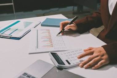 Vergi indirimi konsepti. Kadınlar kişisel gelir vergileri için vergi indirimi almak için harcamaları ve vergileri hesaplamak için bir hesap makinesi kullanıyorlar. Bireyler için vergi beyannamesi. Aylık giderler