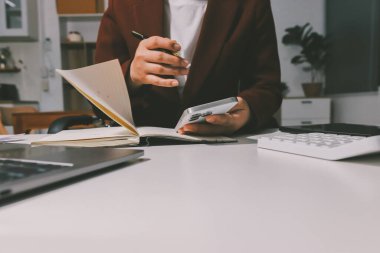 Vergi indirimi konsepti. Kadınlar kişisel gelir vergileri için vergi indirimi almak için harcamaları ve vergileri hesaplamak için bir hesap makinesi kullanıyorlar. Bireyler için vergi beyannamesi. Aylık giderler