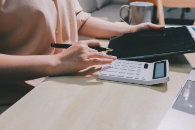 Vergi indirimi konsepti. Kadınlar kişisel gelir vergileri için vergi indirimi almak için harcamaları ve vergileri hesaplamak için bir hesap makinesi kullanıyorlar. Bireyler için vergi beyannamesi. Aylık giderler