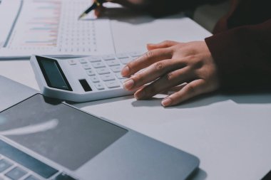 Vergi indirimi konsepti. Kadınlar kişisel gelir vergileri için vergi indirimi almak için harcamaları ve vergileri hesaplamak için bir hesap makinesi kullanıyorlar. Bireyler için vergi beyannamesi. Aylık giderler