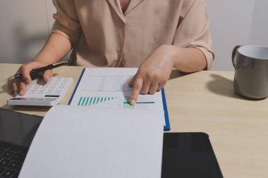 Vergi indirimi konsepti. Kadınlar kişisel gelir vergileri için vergi indirimi almak için harcamaları ve vergileri hesaplamak için bir hesap makinesi kullanıyorlar. Bireyler için vergi beyannamesi. Aylık giderler