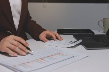 Vergi indirimi konsepti. Kadınlar kişisel gelir vergileri için vergi indirimi almak için harcamaları ve vergileri hesaplamak için bir hesap makinesi kullanıyorlar. Bireyler için vergi beyannamesi. Aylık giderler