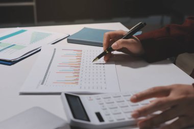 Vergi indirimi konsepti. Kadınlar kişisel gelir vergileri için vergi indirimi almak için harcamaları ve vergileri hesaplamak için bir hesap makinesi kullanıyorlar. Bireyler için vergi beyannamesi. Aylık giderler