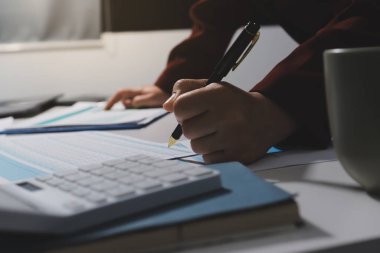 Vergi indirimi konsepti. Kadınlar kişisel gelir vergileri için vergi indirimi almak için harcamaları ve vergileri hesaplamak için bir hesap makinesi kullanıyorlar. Bireyler için vergi beyannamesi. Aylık giderler