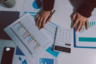 Vergi indirimi konsepti. Kadınlar kişisel gelir vergileri için vergi indirimi almak için harcamaları ve vergileri hesaplamak için bir hesap makinesi kullanıyorlar. Bireyler için vergi beyannamesi. Aylık giderler