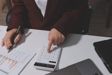 Vergi indirimi konsepti. Kadınlar kişisel gelir vergileri için vergi indirimi almak için harcamaları ve vergileri hesaplamak için bir hesap makinesi kullanıyorlar. Bireyler için vergi beyannamesi. Aylık giderler