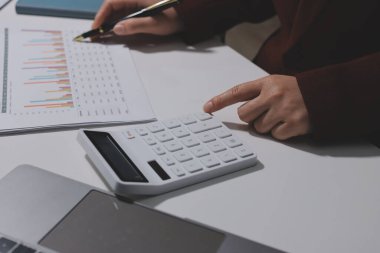 Vergi indirimi konsepti. Kadınlar kişisel gelir vergileri için vergi indirimi almak için harcamaları ve vergileri hesaplamak için bir hesap makinesi kullanıyorlar. Bireyler için vergi beyannamesi. Aylık giderler