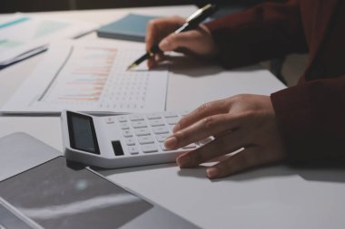 Vergi indirimi konsepti. Kadınlar kişisel gelir vergileri için vergi indirimi almak için harcamaları ve vergileri hesaplamak için bir hesap makinesi kullanıyorlar. Bireyler için vergi beyannamesi. Aylık giderler