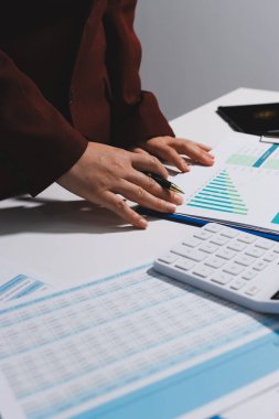 Vergi indirimi konsepti. Kadınlar kişisel gelir vergileri için vergi indirimi almak için harcamaları ve vergileri hesaplamak için bir hesap makinesi kullanıyorlar. Bireyler için vergi beyannamesi. Aylık giderler