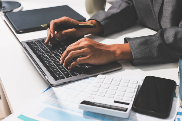 Работая на дому, деловая женщина с ноутбуком и анализируя финансовый отчет.