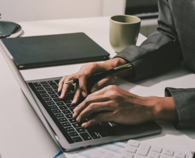 Evden çalışan, iş kadını dizüstü bilgisayar kullanıyor ve mali raporları analiz ediyor..