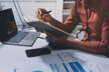 Evden çalışan, iş kadını dizüstü bilgisayar kullanıyor ve mali raporları analiz ediyor..