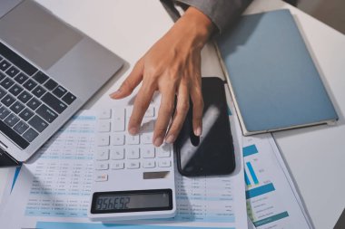 Evden çalışan, iş kadını dizüstü bilgisayar kullanıyor ve mali raporları analiz ediyor..
