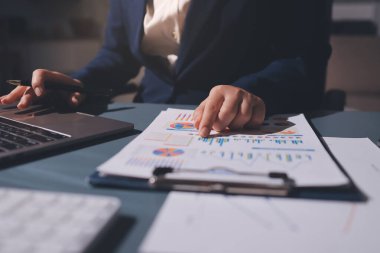 Uzman kadın Asyalı kadınlar idari hesap maliyetli veri numaralarını gözden geçirirler vergi denetleme bürosunda aylık gerçek maliyet varyansı raporu hazırlarlar. ESG tablo bütçe denetimi ERP süreci servis projesi.