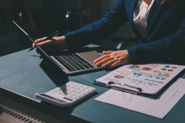 Uzman kadın Asyalı kadınlar idari hesap maliyetli veri numaralarını gözden geçirirler vergi denetleme bürosunda aylık gerçek maliyet varyansı raporu hazırlarlar. ESG tablo bütçe denetimi ERP süreci servis projesi.