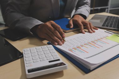 Evden çalışan, iş kadını dizüstü bilgisayar kullanıyor ve mali raporları analiz ediyor..