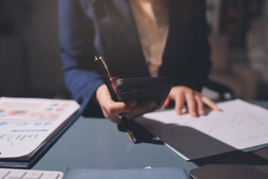 Uzman kadın Asyalı kadınlar idari hesap maliyetli veri numaralarını gözden geçirirler vergi denetleme bürosunda aylık gerçek maliyet varyansı raporu hazırlarlar. ESG tablo bütçe denetimi ERP süreci servis projesi.