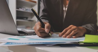 Evden çalışan, iş kadını dizüstü bilgisayar kullanıyor ve mali raporları analiz ediyor..