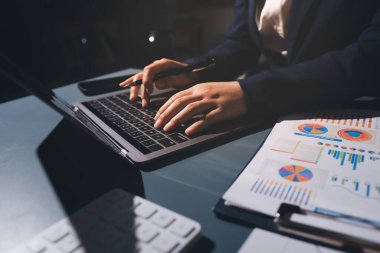 Uzman kadın Asyalı kadınlar idari hesap maliyetli veri numaralarını gözden geçirirler vergi denetleme bürosunda aylık gerçek maliyet varyansı raporu hazırlarlar. ESG tablo bütçe denetimi ERP süreci servis projesi.