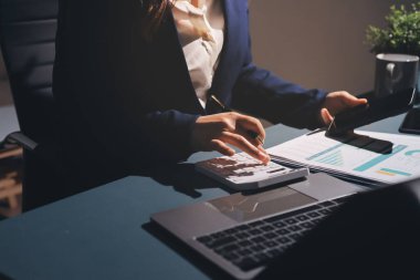 Uzman kadın Asyalı kadınlar idari hesap maliyetli veri numaralarını gözden geçirirler vergi denetleme bürosunda aylık gerçek maliyet varyansı raporu hazırlarlar. ESG tablo bütçe denetimi ERP süreci servis projesi.