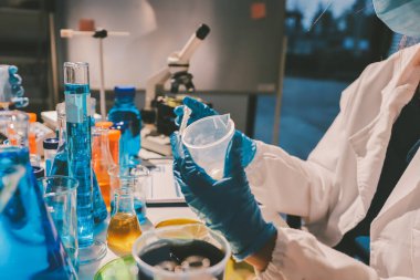 Bilimadamı laboratuarda tıbbi örnekleri mikro plakaya yerleştiriyor.