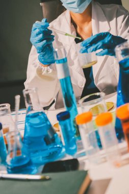 Bilimadamı laboratuarda tıbbi örnekleri mikro plakaya yerleştiriyor.