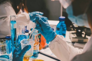 Bilimadamı laboratuarda tıbbi örnekleri mikro plakaya yerleştiriyor.