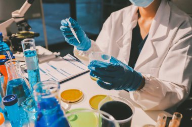 Bilimadamı laboratuarda tıbbi örnekleri mikro plakaya yerleştiriyor.