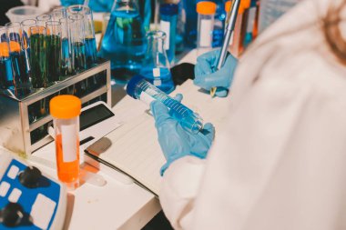 Bilimadamı laboratuarda tıbbi örnekleri mikro plakaya yerleştiriyor.