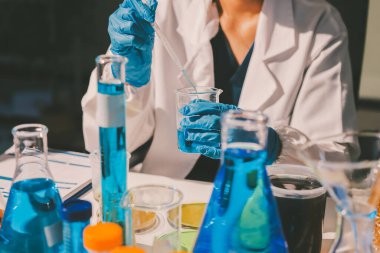 Bilimadamı laboratuarda tıbbi örnekleri mikro plakaya yerleştiriyor.