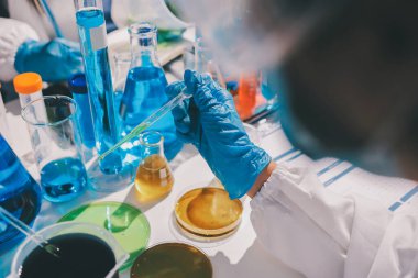 Bilimadamı laboratuarda tıbbi örnekleri mikro plakaya yerleştiriyor.