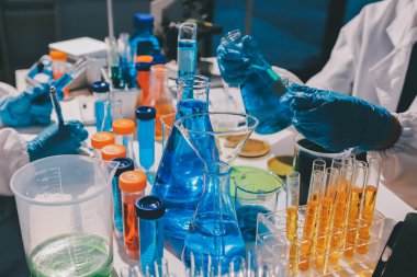 Bilimadamı laboratuarda tıbbi örnekleri mikro plakaya yerleştiriyor.