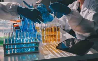 Bilimadamı laboratuarda tıbbi örnekleri mikro plakaya yerleştiriyor.