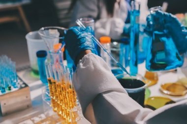 Bilimadamı laboratuarda tıbbi örnekleri mikro plakaya yerleştiriyor.