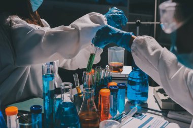 Bilimadamı laboratuarda tıbbi örnekleri mikro plakaya yerleştiriyor.