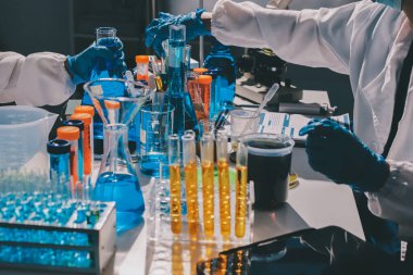 Bilimadamı laboratuarda tıbbi örnekleri mikro plakaya yerleştiriyor.