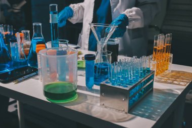 Bilimadamı laboratuarda tıbbi örnekleri mikro plakaya yerleştiriyor.