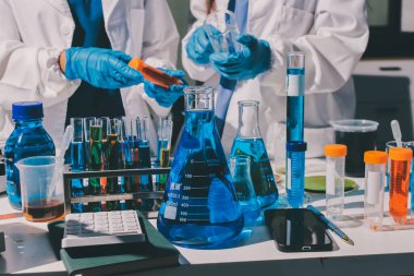 Bilimadamı laboratuarda tıbbi örnekleri mikro plakaya yerleştiriyor.