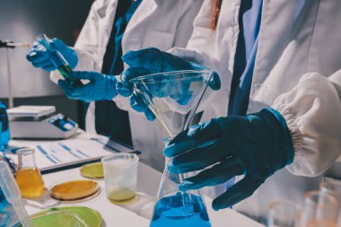 Bilimadamı laboratuarda tıbbi örnekleri mikro plakaya yerleştiriyor.