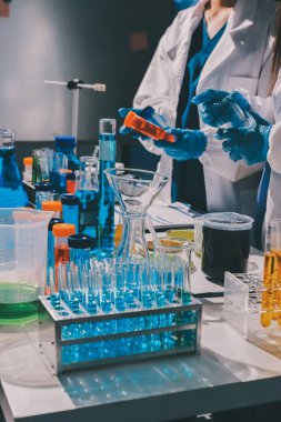 Bilimadamı laboratuarda tıbbi örnekleri mikro plakaya yerleştiriyor.