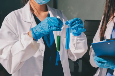 Bilimadamı laboratuarda tıbbi örnekleri mikro plakaya yerleştiriyor.