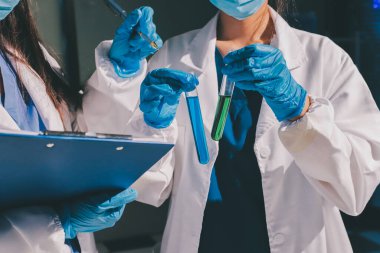 Bilimadamı laboratuarda tıbbi örnekleri mikro plakaya yerleştiriyor.