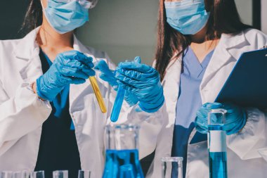 Bilimadamı laboratuarda tıbbi örnekleri mikro plakaya yerleştiriyor.